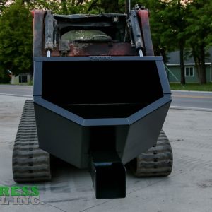 A skid steer with an Express Steel Manual Concrete Placement Bucket is parked on concrete near a road, trees, and a house. The Express Steel Inc. logo appears in the lower left corner.