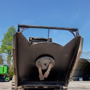 The ES 60" Standard Brush Cutter (up to 60HP) is shown from the front, highlighting its wide cutting blade and sturdy build, with trees and a building in the background under a clear blue sky.