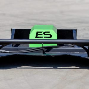 A black and green ES 60" Standard Brush Cutter (up to 60HP) sits on a concrete surface, viewed from the front, with visible cables and aerodynamic elements.